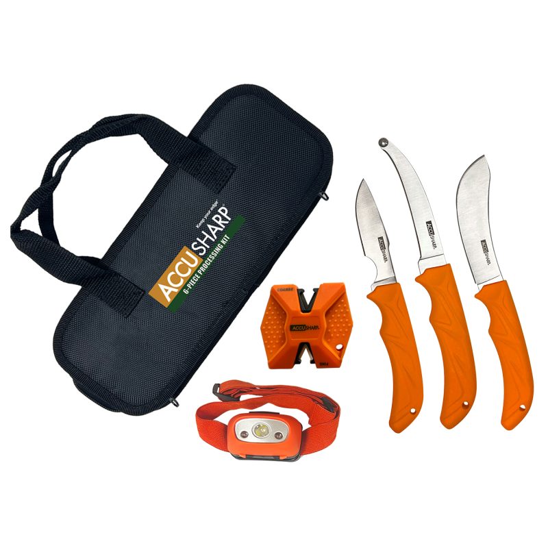 AccuSharp 6-Piece Game Processing Kit with black handles, including caping, butcher, and gutting knives, a sharpener, LED headlamp, and nylon carry case, laid out on a rustic surface.