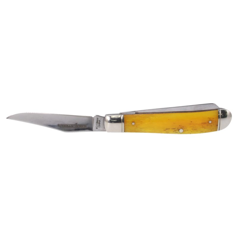 Cold Steel Mini Trapper folding knife with yellow bone handle and two polished silver blades, shown open on a rustic surface.
