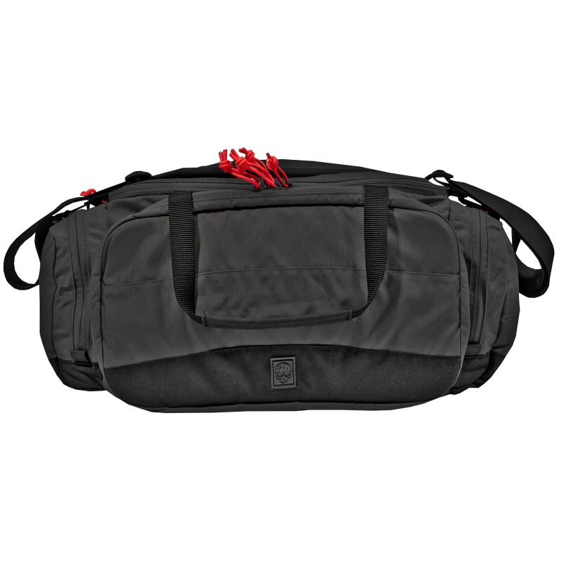 Black Grey Ghost Gear Range Bag with red zipper pulls, showing the main compartment and shoulder strap, on a rugged outdoor surface.