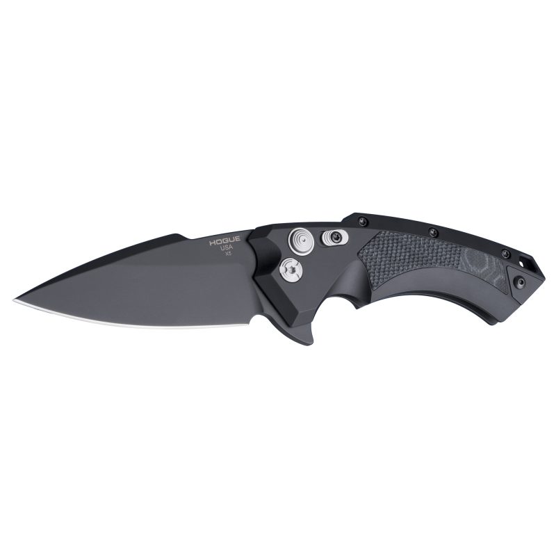A black Hogue X5 folding knife with a spear point blade and G10 handle inserts, shown closed on a rugged surface.