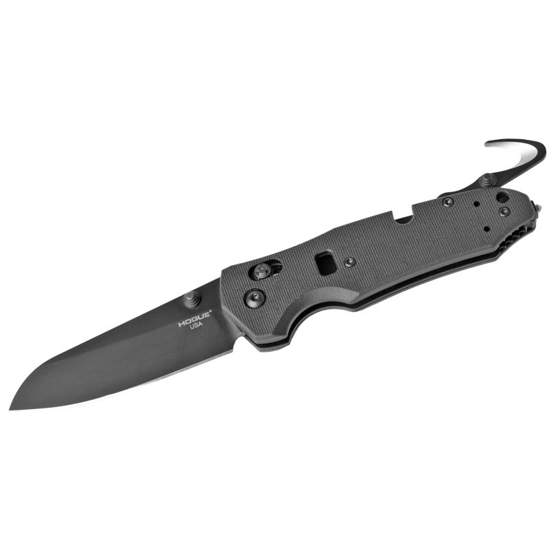Hogue Trauma 3.4 inch Tool Able folding knife with black Cerakote blade and black G10 handle, shown open on a rustic surface.