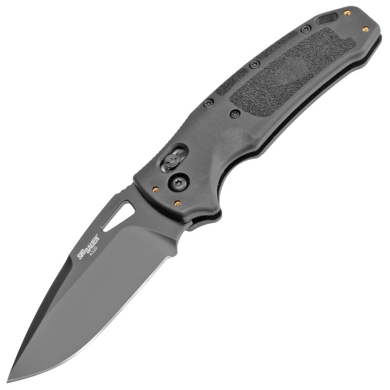 Hogue Sig K320 Nitron folding knife with a black handle and 3.5-inch drop point blade, shown open on a rustic surface.