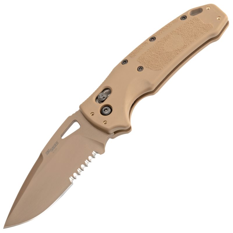 Hogue K320 M17 folding knife with a 3.5-inch drop point blade and coyote tan handle, shown open on a rustic surface.