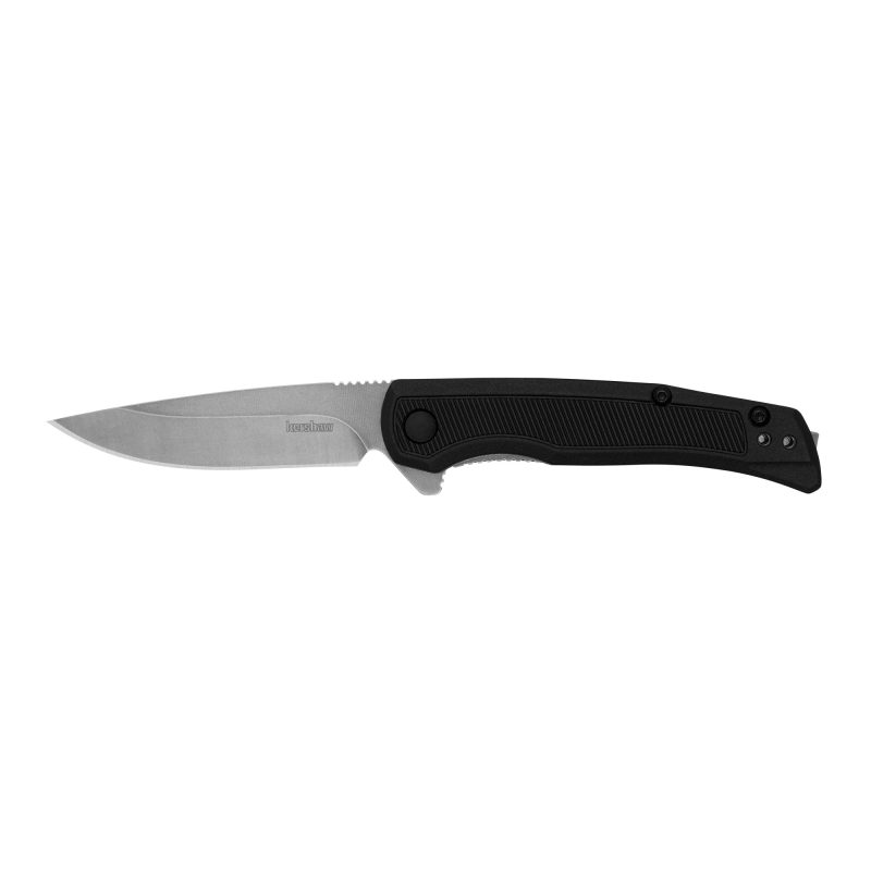 Kershaw Outfield folding knife with a black glass-filled nylon handle and a stone-washed 2.8-inch clip point blade, shown open on a rustic background.