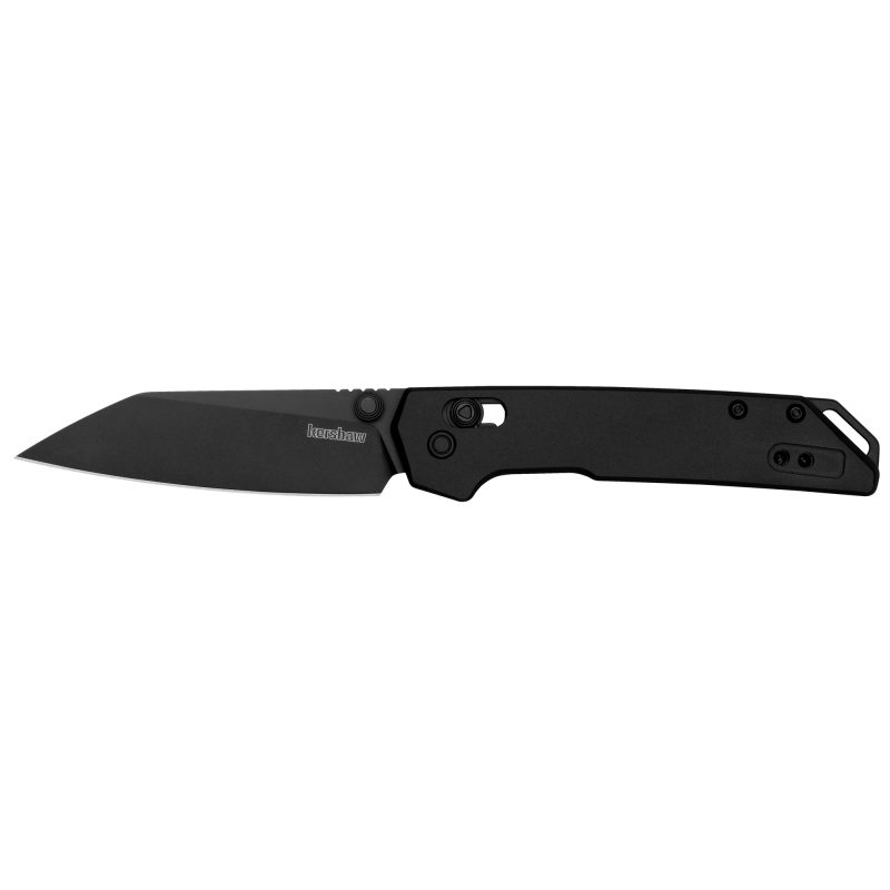 Kershaw Mini Iridium folding knife with a black reverse tanto blade and black handle, shown closed and open on a rugged surface.