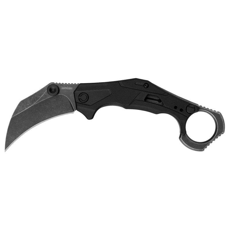 Kershaw Outlier 2.6 inch Blackwash assisted open folding karambit knife with black handle and finger ring, shown partially open on a rustic surface.