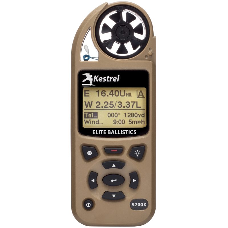Tan Kestrel 5700X Elite weather meter with ballistics, showing display and buttons, on a rugged outdoor surface.