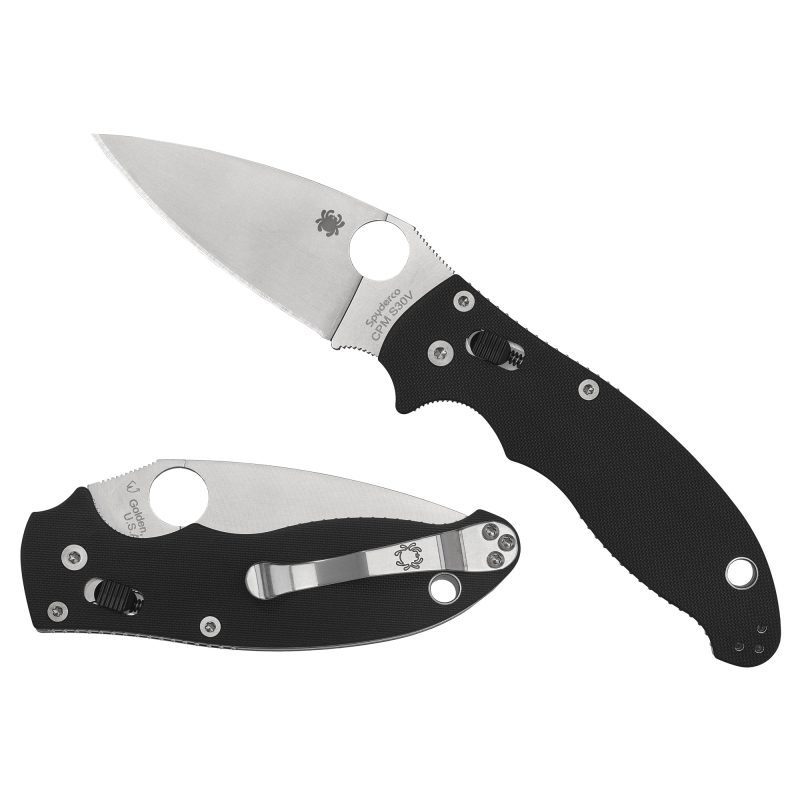 Spyderco Manix 2 folding knife with a black G10 handle and a plain edge CPM-S30V blade, shown open on a rustic surface.