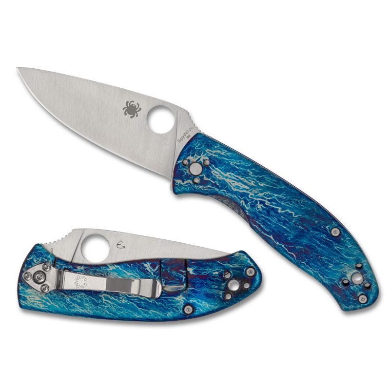 Spyderco Tenacious folding knife with a silver D2 steel drop point blade and blue titanium handle with a unique disarray finish, shown open.
