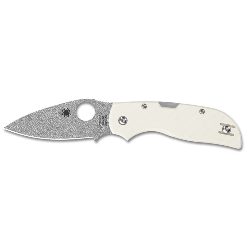 Spyderco Chaparral folding knife with a Damascus patterned blade and white G-10 handle, shown open on a rustic surface.