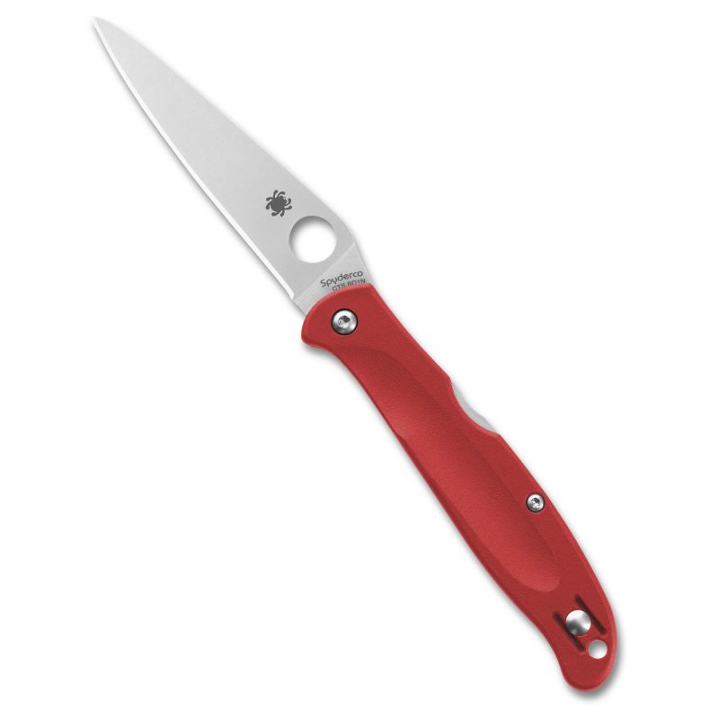 Red handle Spyderco Charisma folding knife with a satin finish drop point blade open on a rustic surface.