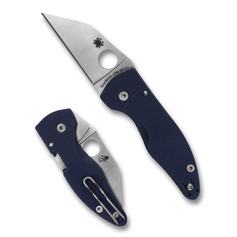 Spyderco Microjimbo G10 folding knife with a blue handle and satin finish Wharncliffe blade, shown open on a rustic surface.