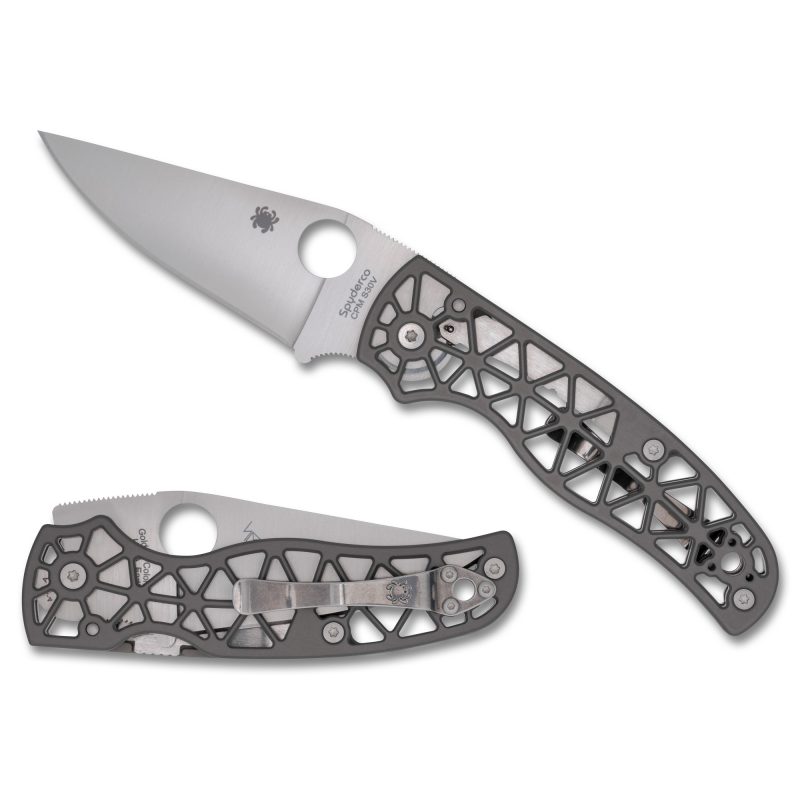 Spyderco Edgerati Geometric folding knife with a silver clip point blade and gray aluminum handle, shown open on a rustic surface.
