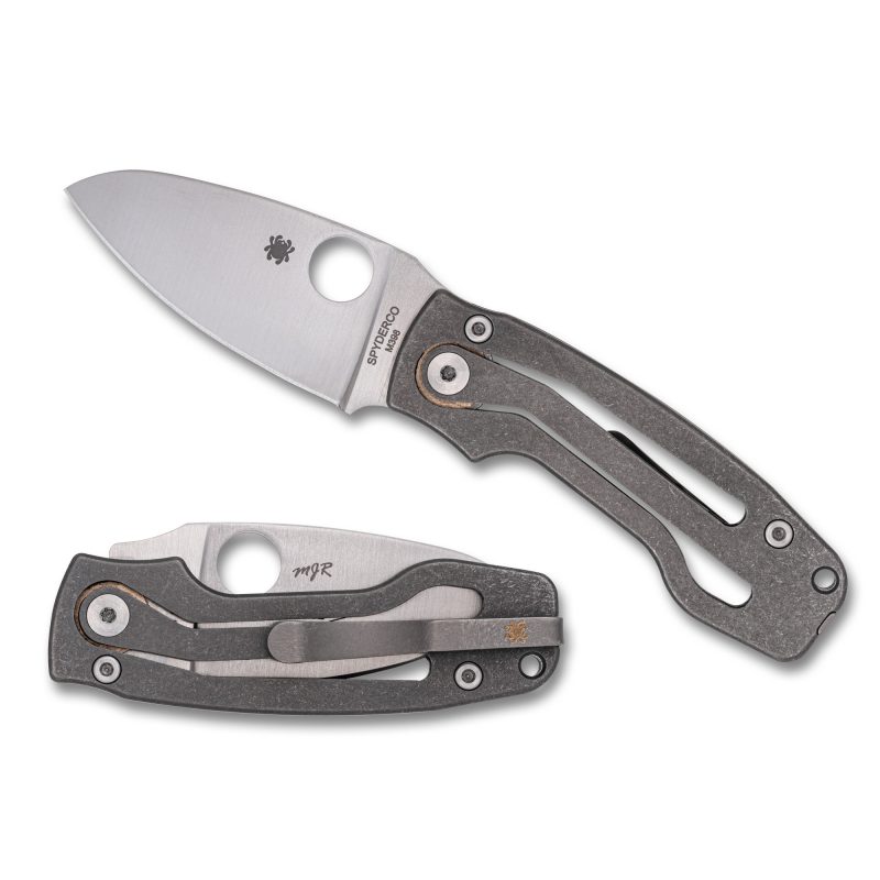 A Spyderco Pits 2 Slipit folding knife with a gray titanium handle and a satin-finished drop point blade, shown open on a rustic surface.