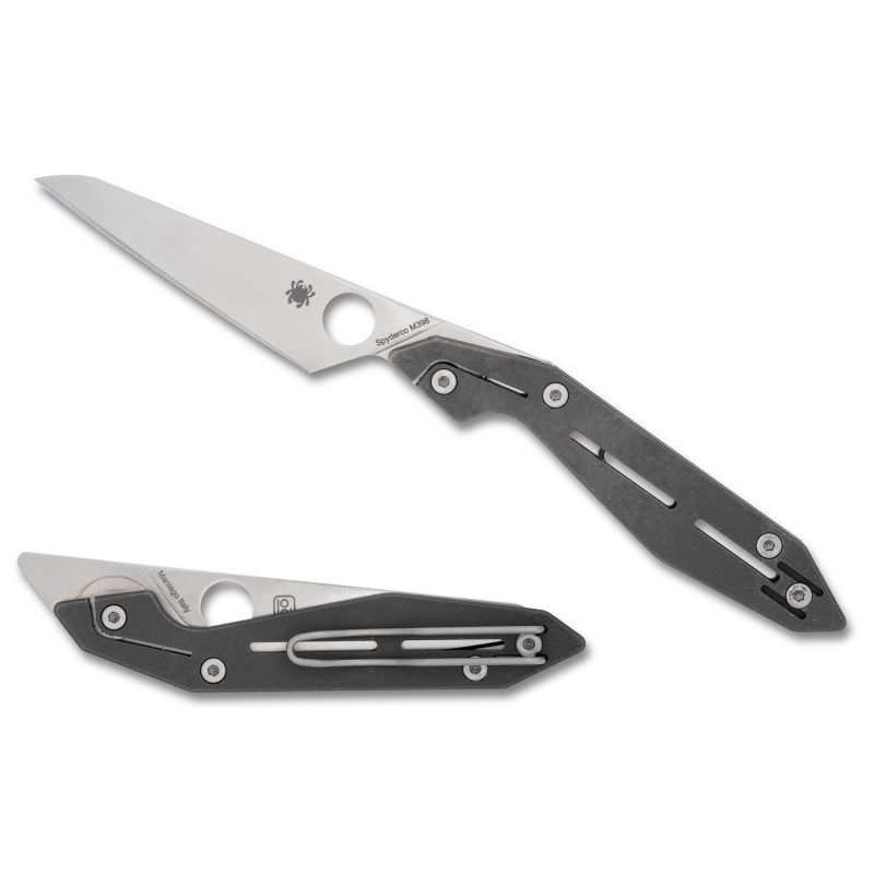 Close-up of a silver Spyderco Nand folding knife with a Wharncliffe blade and gray titanium handle, open on a rustic surface.