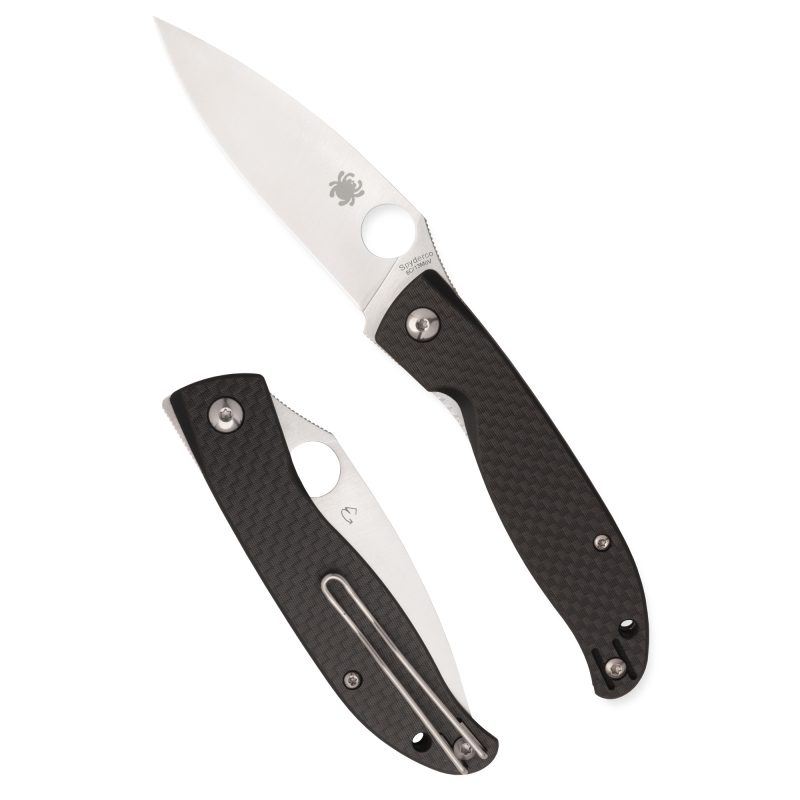 Spyderco Mantra 4 folding knife with a satin finish drop point blade and black carbon fiber handle, shown open on a rustic background.