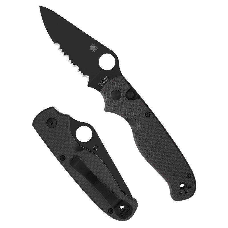 Spyderco ButtonUp Carbon Fiber folding knife with 3.27 inch black oxide combination edge blade and black carbon fiber handle, shown open on a rustic surface.