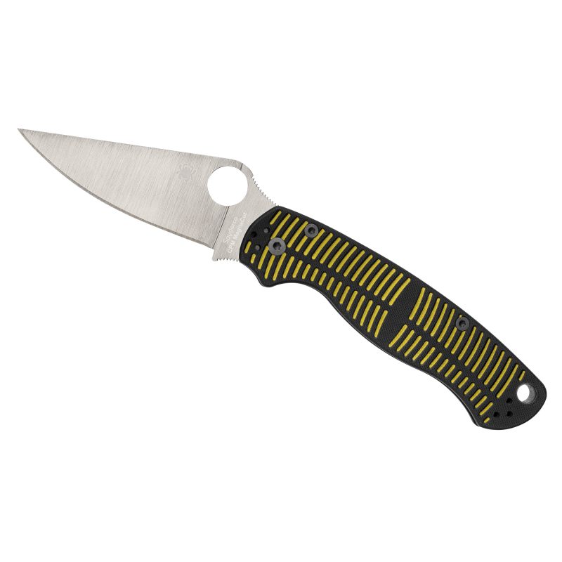 Spyderco Para Military 2 Salt folding knife with a silver plain edge MagnaCut blade and a black and yellow G10 handle, shown open on a rustic surface.