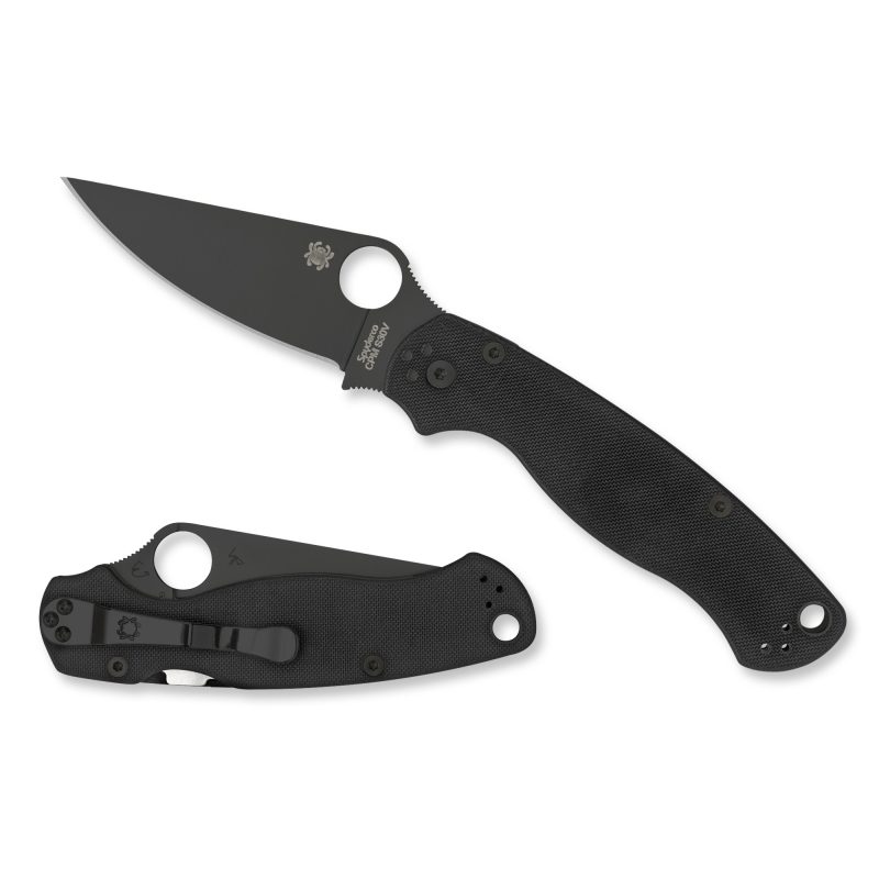 Spyderco Para Military 2 folding knife with black G10 handle and black DLC finish blade, shown open on a rustic surface.