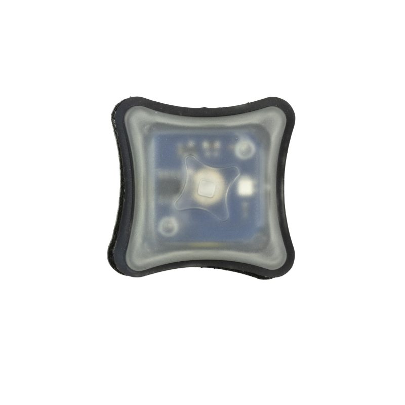 Unity Tactical Spark Light Blue marker light with Velcro backer, shown against a matte black background, ready for attachment to outdoor gear.