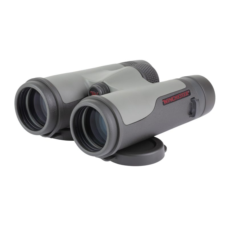 Winchester Supreme 8X42Mm Binocular in black and gray, with lens covers, cleaning cloth, chest harness, and padded case, shown against an outdoor background.
