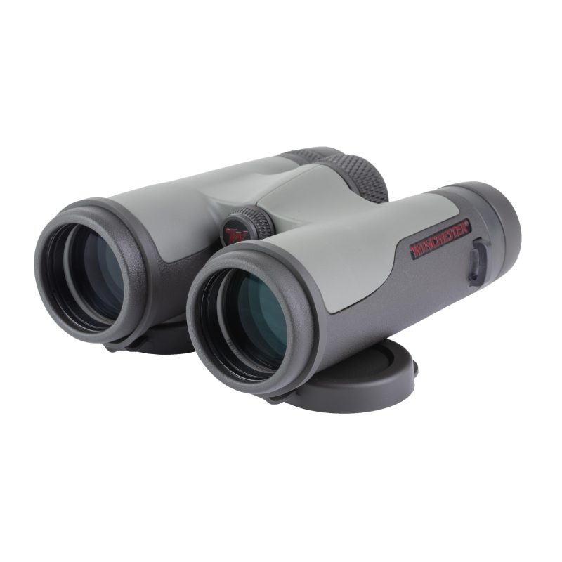 A black and gray Winchester Supreme Optics 10X42mm binocular with lens covers, cleaning cloth, chest harness, and padded case.